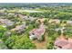 Expansive aerial view capturing the community's layout, showcasing well-maintained homes, lush greenery, and a serene lake at 9729 Lake Hugh Dr, Gotha, FL 34734