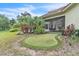 Backyard features a putting green, screened-in patio, and beautifully landscaped greenery at 9729 Lake Hugh Dr, Gotha, FL 34734