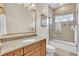 Bathroom with wood vanity, granite countertop, and tile-enclosed shower/tub combo at 9729 Lake Hugh Dr, Gotha, FL 34734
