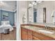 Bathroom features a double vanity with granite countertop, wood cabinets, and a bedroom in view at 9729 Lake Hugh Dr, Gotha, FL 34734