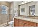Bright bathroom features a granite vanity, framed mirror, and glass-enclosed shower at 9729 Lake Hugh Dr, Gotha, FL 34734