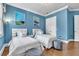Inviting bedroom showcasing two twin beds, stylish decor, and calming blue walls at 9729 Lake Hugh Dr, Gotha, FL 34734