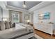 Spacious bedroom with tray ceiling, desk area, and calming beach-themed decor at 9729 Lake Hugh Dr, Gotha, FL 34734