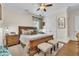 Well-lit bedroom features a wooden bed frame, neutral decor, and plush seating at 9729 Lake Hugh Dr, Gotha, FL 34734