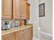 A coffee bar with granite countertops, wooden cabinets, and decorative stone backsplash at 9729 Lake Hugh Dr, Gotha, FL 34734