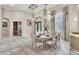 Elegant dining room featuring tiled floors, chandelier, set table and decorative iron doors at 9729 Lake Hugh Dr, Gotha, FL 34734