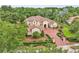 Stunning stucco home with a tile roof, circular driveway, and lush landscaping, creating an inviting curb appeal at 9729 Lake Hugh Dr, Gotha, FL 34734