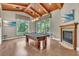 Spacious game room with a pool table, hardwood floors, and a fireplace with a beautiful wooden ceiling at 9729 Lake Hugh Dr, Gotha, FL 34734
