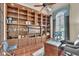 A traditional home office with custom built-ins, hardwood floors, and arched windows at 9729 Lake Hugh Dr, Gotha, FL 34734