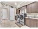 A laundry room with elevated front load washer and dryer plus ample counter and cabinet space at 9729 Lake Hugh Dr, Gotha, FL 34734
