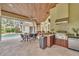 Spacious covered patio including dining and outdoor kitchen areas, perfect for entertaining guests at 9729 Lake Hugh Dr, Gotha, FL 34734