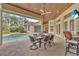 Covered patio featuring a dining table, seating, and an outdoor kitchen with a view of the pool at 9729 Lake Hugh Dr, Gotha, FL 34734