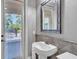 A pool bathroom with modern fixtures, tiled accent wall, and view of the pool area at 9729 Lake Hugh Dr, Gotha, FL 34734