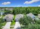 Aerial view of charming homes with lush green landscaping and a serene pond in a tranquil neighborhood at 10875 Arbor View Blvd, Orlando, FL 32825