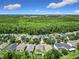 An aerial view of a suburban neighborhood showcases tree-lined streets and well-maintained homes, with a dense forest in the distance at 10875 Arbor View Blvd, Orlando, FL 32825