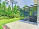 Exterior view of a home's screened lanai and backyard with lush greenery at 10875 Arbor View Blvd, Orlando, FL 32825