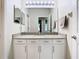 Bright bathroom featuring a large mirror, white cabinets, and granite countertops at 10875 Arbor View Blvd, Orlando, FL 32825