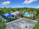 A community amenities featuring a playground with a blue canopy, a clubhouse, and a pool area surrounded by lush trees at 10875 Arbor View Blvd, Orlando, FL 32825