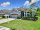Beautiful home featuring a two-car garage, manicured lawn, and lovely landscaping at 10875 Arbor View Blvd, Orlando, FL 32825