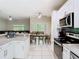 Open kitchen features white cabinets, granite counters, and stainless steel appliances at 10875 Arbor View Blvd, Orlando, FL 32825