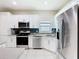 Well-lit kitchen features stainless steel appliances, white cabinets, and a stylish backsplash at 10875 Arbor View Blvd, Orlando, FL 32825