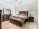 Main bedroom with wood floors features a tray ceiling and a view of the outdoors at 10875 Arbor View Blvd, Orlando, FL 32825