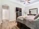 Comfortable bedroom featuring wood-look floors, TV, and tray ceiling with ceiling fan at 10875 Arbor View Blvd, Orlando, FL 32825