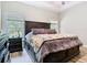 Bright main bedroom with large headboard, side tables, and two windows at 10875 Arbor View Blvd, Orlando, FL 32825