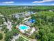 Aerial view of a community pool featuring a large pool deck, ample lounge seating, and blue sun shades in a lush neighborhood at 10875 Arbor View Blvd, Orlando, FL 32825