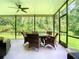 Relaxing screened-in porch with ceiling fan and wicker furniture, perfect for outdoor dining at 10875 Arbor View Blvd, Orlando, FL 32825