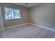 An empty bedroom with light gray walls, a window, and light wood-look tile flooring at 126 Ingram Cir, Longwood, FL 32779
