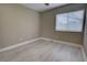 An empty bedroom with light gray walls, a window, and light wood-look tile flooring at 126 Ingram Cir, Longwood, FL 32779