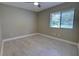 An empty bedroom with light gray walls, a window, and light wood-look tile flooring at 126 Ingram Cir, Longwood, FL 32779