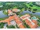 Scenic aerial view showcases community buildings, lush landscaping, lake, and nearby golf course, highlighting resort-style living at 1392 Lombardi Ct, Kissimmee, FL 34759