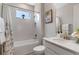 Bright bathroom featuring a shower-tub combination and a white vanity with a sleek, modern design at 1392 Lombardi Ct, Kissimmee, FL 34759