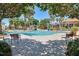 Community pool area with ample lounge chairs and shade trees, ideal for relaxation and socializing at 1392 Lombardi Ct, Kissimmee, FL 34759