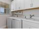 Efficient laundry room featuring a washing machine, dryer, and ample storage with white cabinets at 1392 Lombardi Ct, Kissimmee, FL 34759
