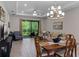Open-concept living room with tiled floors, modern lighting, and sliding glass doors to outdoor space at 1392 Lombardi Ct, Kissimmee, FL 34759