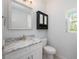 Cozy bathroom with a vanity, decorative mirror, and a modern toilet at 141 W Main St, Lake Helen, FL 32744