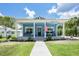 Charming blue cottage-style home with a welcoming front porch and well-manicured lawn at 141 W Main St, Lake Helen, FL 32744