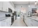 Bright kitchen with white cabinets, marble countertops, and stainless steel appliances at 141 W Main St, Lake Helen, FL 32744