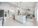 Open-concept kitchen with a large island, white cabinets, and stainless steel appliances at 141 W Main St, Lake Helen, FL 32744