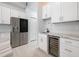 Modern kitchen with white cabinetry, a wine cooler, and stainless steel appliances at 141 W Main St, Lake Helen, FL 32744