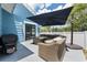 Outdoor patio with wicker seating and grill under a dark blue umbrella at 141 W Main St, Lake Helen, FL 32744