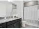 This bathroom features a granite topped vanity with dark wood cabinets and a shower and tub combo at 14366 Alafaya Oak Bnd, Orlando, FL 32828