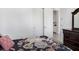 Cozy bedroom with neutral walls, a dark wood dresser, and a view into a bathroom at 14366 Alafaya Oak Bnd, Orlando, FL 32828