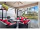 Inviting screened lanai features comfortable seating around a fire table, a TV, and an adjacent refreshing pool at 14366 Alafaya Oak Bnd, Orlando, FL 32828