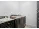 The laundry room features a front loading washer and dryer, a granite topped sink, and dark wood cabinets at 14366 Alafaya Oak Bnd, Orlando, FL 32828