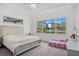 The main bedroom has light gray carpeting, a trey ceiling, a large window, and a silver bed frame at 14366 Alafaya Oak Bnd, Orlando, FL 32828