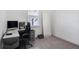 This office space features light gray carpeting, a window, a printer, and a computer on a white desk at 14366 Alafaya Oak Bnd, Orlando, FL 32828